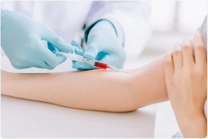 Certified phlebotomist performing a blood draw at a walk-in laboratory in Houston, Texas.